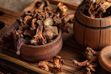 Dried chanterelle mushrooms, on a wooden board, on a rough woven background, burlapの写真素材