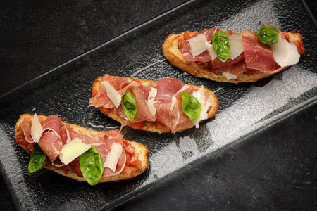 Mouthwatering Bruschetta Topped with Smoked Salmon, Ham and Parmesan Cheese. close upの写真素材