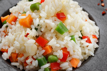 Risotto with vegetables and spices on a black plate, on a black backgroundの写真素材