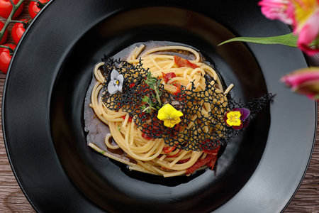 Appetizing Spaghetti with Cherry Tomatoes on Black Plateの写真素材