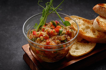 Eggplant vegetable caviar on a wooden board, on dark concreteの写真素材