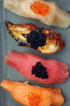 Assorted Nigiri sushi on a plate, on dark concreteの写真素材