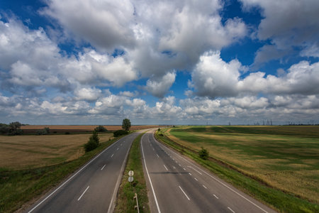 Highway, fields. beautiful sky with white clouds