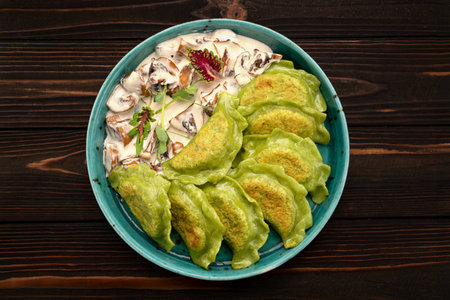 Green dumplings with spinach and fried mushrooms in creamy sauceの写真素材