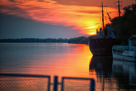 Old ships near the river bank at sunsetの写真素材