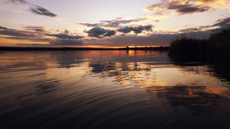 Scenic sunset view over a calm lake with soft reflections and a tranquil atmosphere. Perfect for themes of ecology, environment, and natural beauty.の写真素材