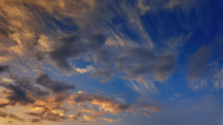 Soft and colorful dawn sky with tinted fluffy clouds. Perfect for wallpapers and backgrounds. Highlights themes of atmosphere, ecology, environmentの写真素材