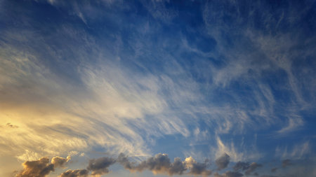 Soft and colorful dawn sky with tinted fluffy clouds. Perfect for wallpapers and backgrounds. Highlights themes of atmosphere, ecology, environmentの写真素材