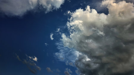 Dramatic blue sky with approaching storm clouds. Ideal for wallpapers and backgrounds. Highlights environmental themes like climate change, atmosphereの写真素材