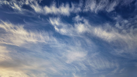Soft and colorful dawn sky with tinted fluffy clouds. Perfect for wallpapers and backgrounds. Highlights themes of atmosphere, ecology, environmentの写真素材