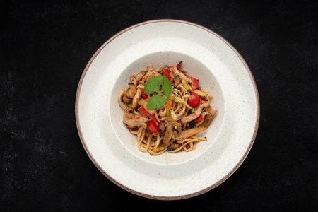 Tasty spaghetti with mushrooms, chicken, and vegetables, ideal for restaurant menus, food advertising, and culinary promotions.の写真素材