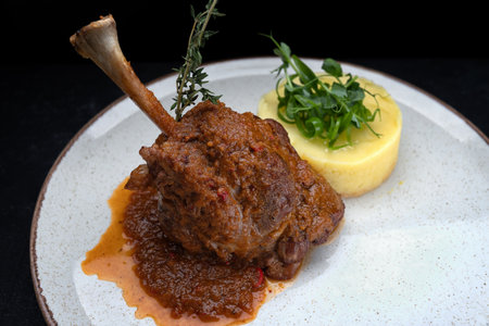 Savory roasted lamb leg served with mashed potatoes, perfect for restaurant menus, culinary advertising, and gourmet promotions.の写真素材
