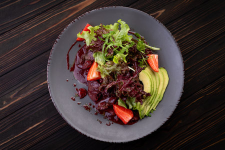Gourmet warm salad with liver, avocado, and strawberries, ideal for menu and food promo.の写真素材