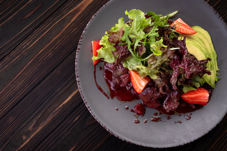 Gourmet warm salad with liver, avocado, and strawberries, ideal for menu and food promo.の写真素材