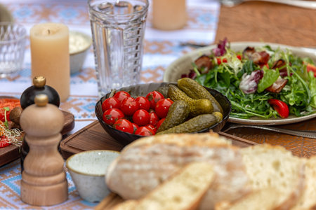 Assorted pickled cucumbers and tomatoes served on a traditional table setting, fresh, rustic,...
