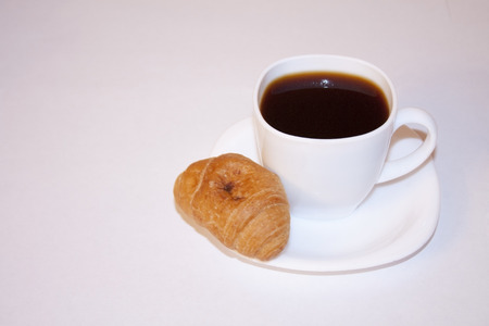 Cup of coffe and vanilla croissant with chocolate. Delicious and fragrant breakfast.の写真素材