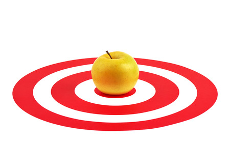 Apple in the center of red target over white backgroundの写真素材