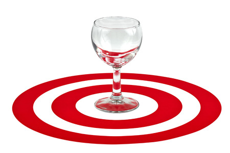 Wine glass in the center of red target over white backgroundの写真素材