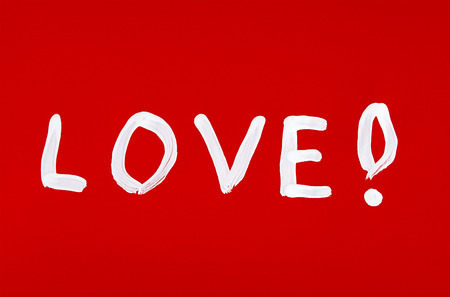 Love word painted over red backgroundの写真素材