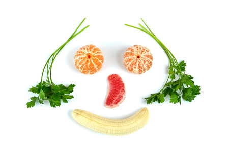 Face made of various fruits and parsley over white backgroundの写真素材
