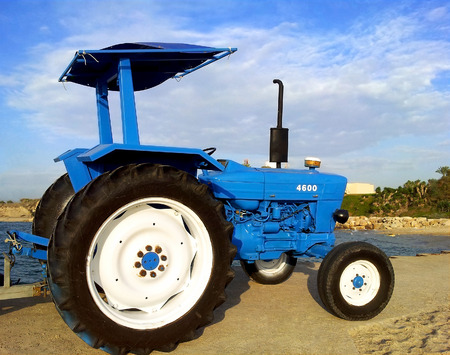 Blue farming tractor truck engine on the beach