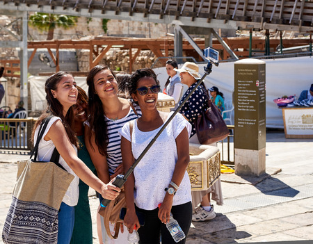 JERUSALEM, ISRAEL - JUNE 4, 2015: Smiling girls are taking selfie shot near the Western Wall and Temple Mount in Jerusalem. The Western Wall and Temple Mount are the most famous landmarks in Israel. There are always a plenty of tourists.のeditorial素材