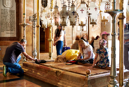 Jerusalem, Israel - June 06, 2015: Prayers at the Stone of Anointing in the Holy Sepulchre Church in Jerusalem. The Holy Sepulchre Church is the most sacred place for all Christians in the world.のeditorial素材