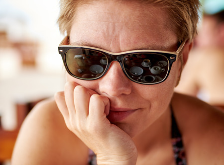 Pretty girl with reflection in sunglasses in a cafeの写真素材