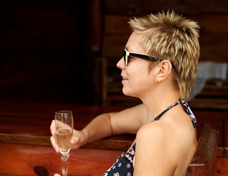 Beautiful girl in bikini drinking champagne at the bar counterの写真素材