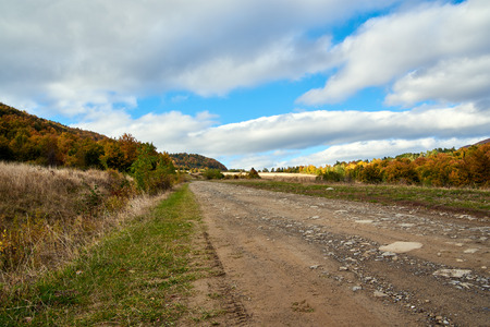 Mountain road lanscape with clouds and colorful trees. Alps.の写真素材