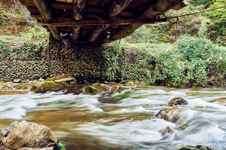 Mountain stream river with rapids under the bridgeの写真素材