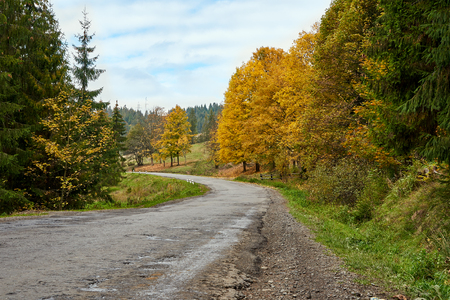 Mountain road lanscape with clouds and colorful trees. Alps.の写真素材