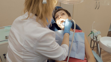 Woman at the dentist clinic office gets dental medical examination and treatment. Odontic and mouth health is important part of modern human life that dentistry help with.の写真素材