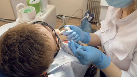 Woman at the dentist clinic office gets dental medical examination and treatment. Odontic and mouth health is important part of modern human life that dentistry help with.の写真素材