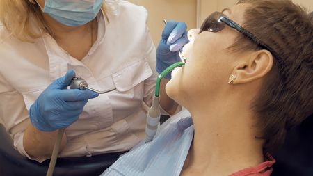 Woman at the dentist clinic office gets dental medical examination and treatment. Odontic and mouth health is important part of modern human life that dentistry help with.の写真素材