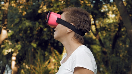 Young woman explores virtual reality using VR glasses. Augmented reality quickly comes into human...