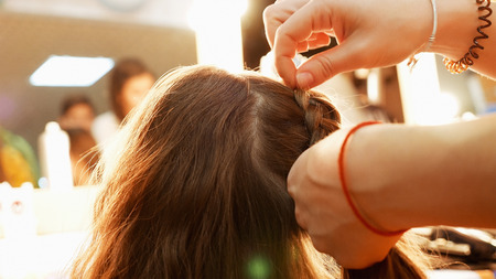 Female model getting her hair dressed before an event. Makeup appearance and hairstyle are important for every beautiful woman.の写真素材