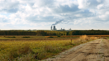 Factory smoke stack and pipes puff into air. Atmospheric air pollution industrial scene. Non-ecological and non-sustainable manufacturing.の写真素材