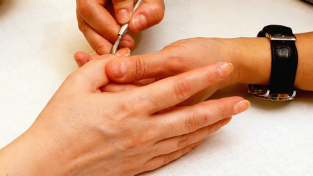 Manicure in the beauty salon. Painting and polishing nails. Spa nails cuticle scarfskin procedure.の写真素材