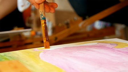 Artist paints a picture oil painting artwork drawing on canvas easel in art studio. Student learning to draw and paint.の写真素材