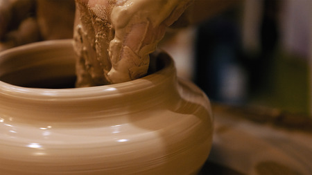 Potter is making clay pot bowl or vase ceramics porcelain on the potters wheel. Creating pottery art...