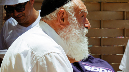 Jerusalem, Israel - May 25, 2017: Jewish senior old man with beard talks with emotions and...