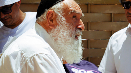 Jerusalem, Israel - May 25, 2017: Jewish senior old man with beard talks with emotions and expression to another man outdoors. All jews are used to wear the kippah or yarmulke small hat.のeditorial素材