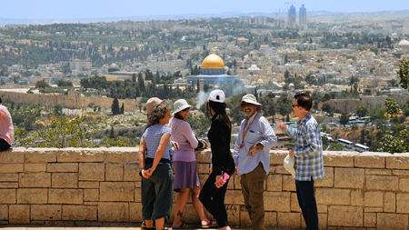Jerusalem, Israel - May 25, 2017: The guide shows the Jerusalem Old City view to the tourists and...