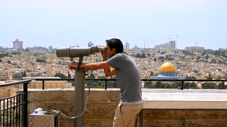 Jerusalem, Israel - May 25, 2017: Tourist looks in binoculars tower viewer at the Jerusalem Old City...