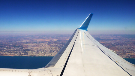 Passenger plane airliner is flying along the sea coast after takeoff.の写真素材