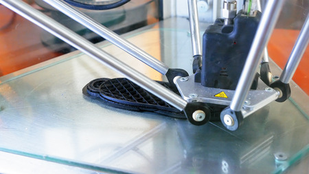 3D printer performs product creation. Modern 3D printing or additive manufacturing and robotic...