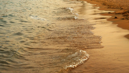 Soft sea waves rushing on the sandy beach at the sunset. The most tranquil and serene scene at the sea surf. Calm sea at night.の写真素材