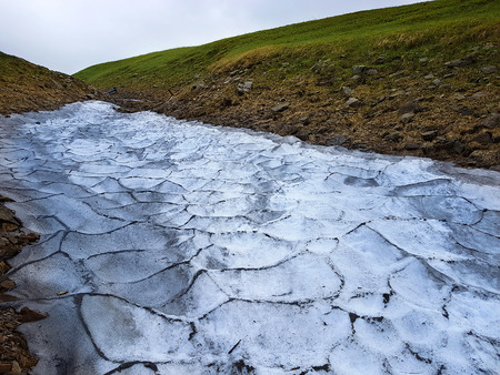 Glacier in mountains with green grassの写真素材