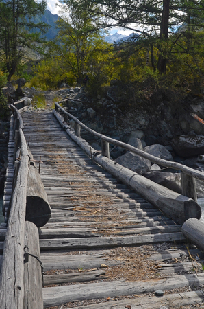 Wooden bridge across mountain stream. Altai Republic, Russiaの写真素材